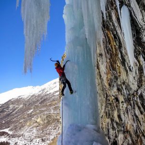 zdjęcie przedstawiające alpinistę podczas wspinaczki górskiej