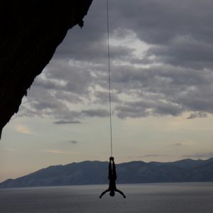 zdjęcie przedstawiające zwisającego na linię alpinistę